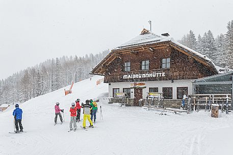 Skiers in front of Maibrunnhtte mountian hut on the top of Maibrunnbahn alpine station, Bad Kleinkirchheim, Carinthia, Austria, Europe