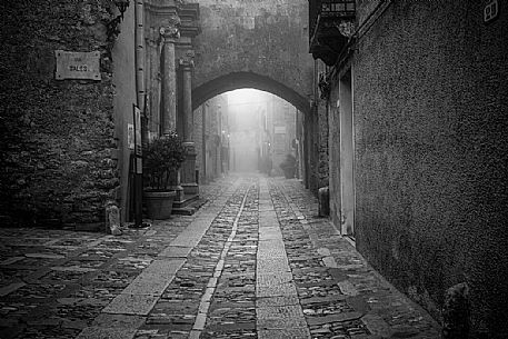 Alley in old town of Erice village in a foggy day, Sicily, Italy, Europe