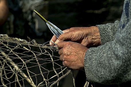 Repairing fishing nets in the harbour of Camogli, Little Tonnara of Camogli, Liguria, Italy