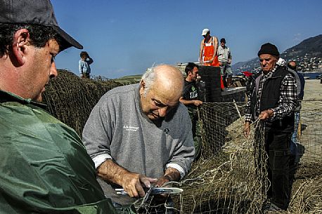 Repairing fishing nets in the harbour of Camogli, Little Tonnara of Camogli, Liguria, Italy