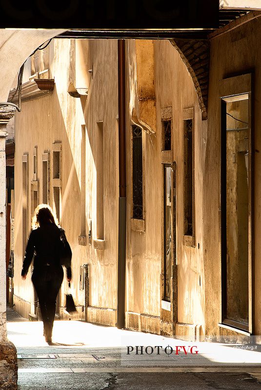 A woman walks in the historic center of Pordenone, Friuli Venezia Giulia, Italy, Europe