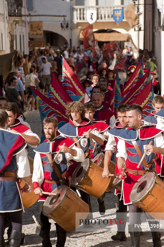 Flag-waving and drummers along the historical street of the village in a historical reconstruction of Valvasone, Friuli Venezia Giulia, Italy