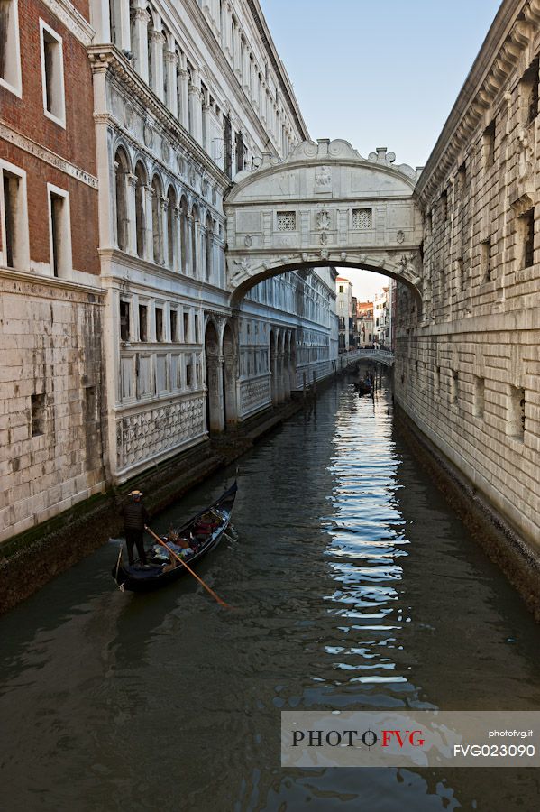 Tourists in a gondola admire the Bridge of Sighs for Ponte dei Sospiri, Venice. Italy.
