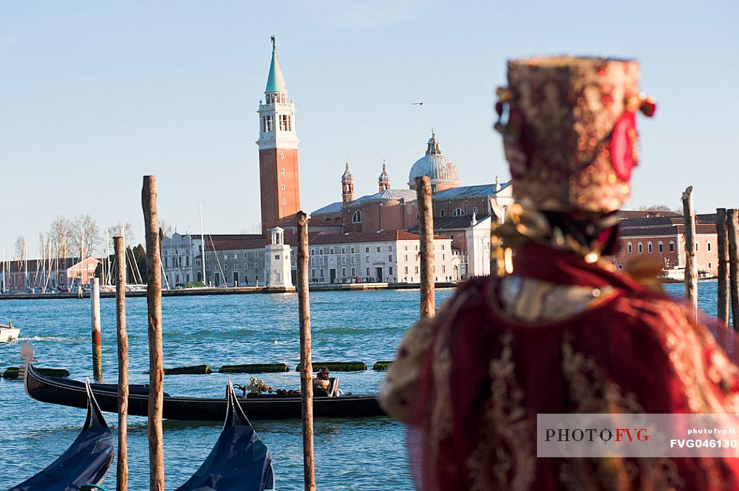 A carnival mask in Venice looking San Giorgio Maggiore from Piazza San Marco square, Venice, Italy, Europe