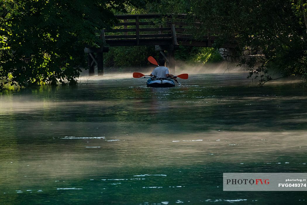 Tourists in canoes enjoy the panorama of the Livenza river near the source called 