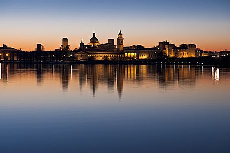 The profile of the city of Mantua, Unesco Heritage and Italian capital of culture, is reflected in the Middle Lake at sunset. Italy