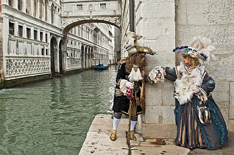 Beautiful couple of masks at bridge of Sighs during the carnival of Venice, Italy, Europe