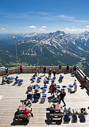 Tourists enjoy the view of the Dolomites and the Sorapiss group from the panoramic terrace of Cima Tofana peak, Cortina d'Ampezzo. Belluno, Italy.