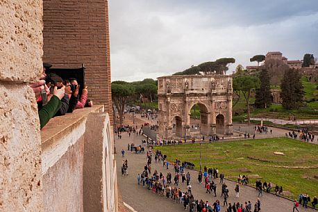 From the top of the Colosseum, tourists photograph the Arch of Titus or Arco di Tito, Roman Forum, Rome, Italy, Europe