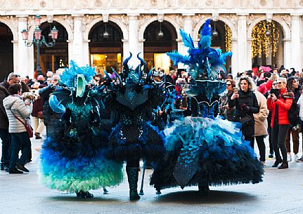 Tourists photograph carnival masks in San Marco square in Venice, Italy, Europe