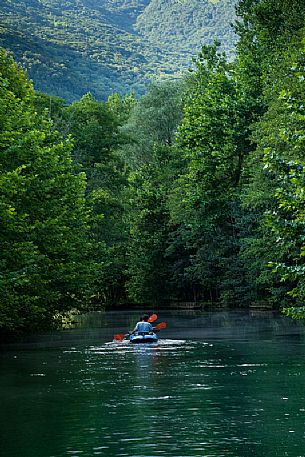 Tourists in canoes enjoy the panorama of the Livenza river near the source called 