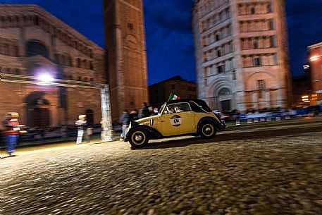 Vintage car race in the Piazza Duomo square with Baptistery and Cathedral, Parma, Italy