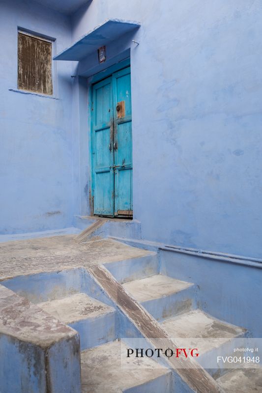 Detail of a street in Bundi with typical blue walls and colored door, Rajasthan, India