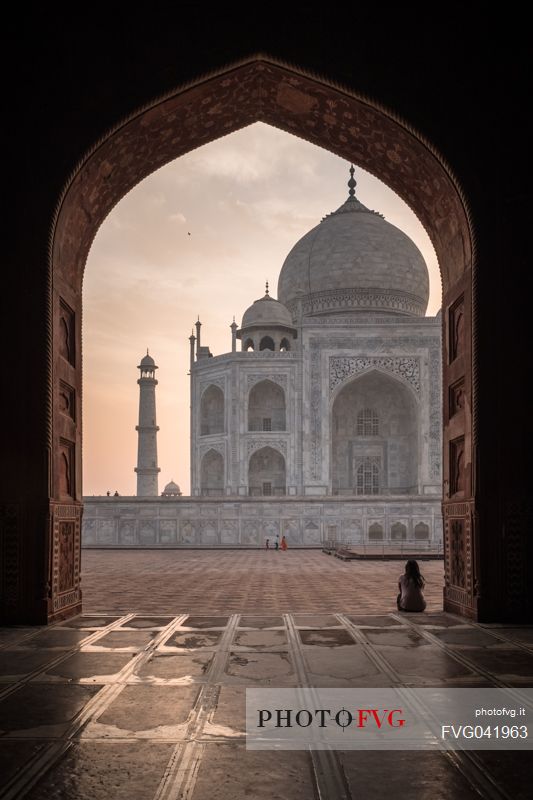 Woman sitting in front of the Taj Mahal, one of the seven wonders of the modern world, Agra, Uttar Pradesh, India
