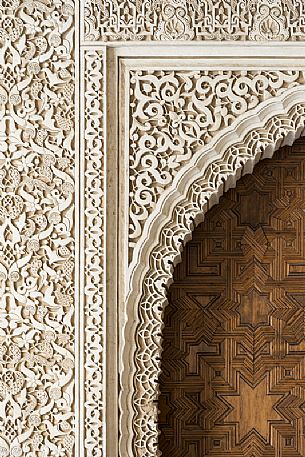 Detail of a door and wall decoration in the Arrayanes Patio, part of teh Nazaries Palace, in the Alhambra complex, Granada, Spain