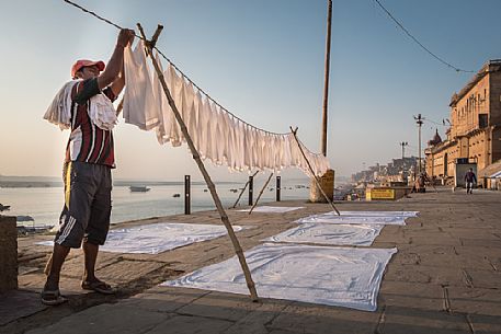 Man hanging out the laundry on the banks of the Ganges river in Varanasi, Uttar Pradesh,India