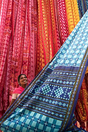 Woman working in a sari factory shows the colorful textiles, Rajasthan, India