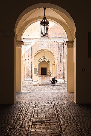 Main entrance of Gambalunga library in Rimini which opens up into a beautiful courtyard with a 17th century well at its centre, Rimini, Emilia Romagna, Italy, Europe