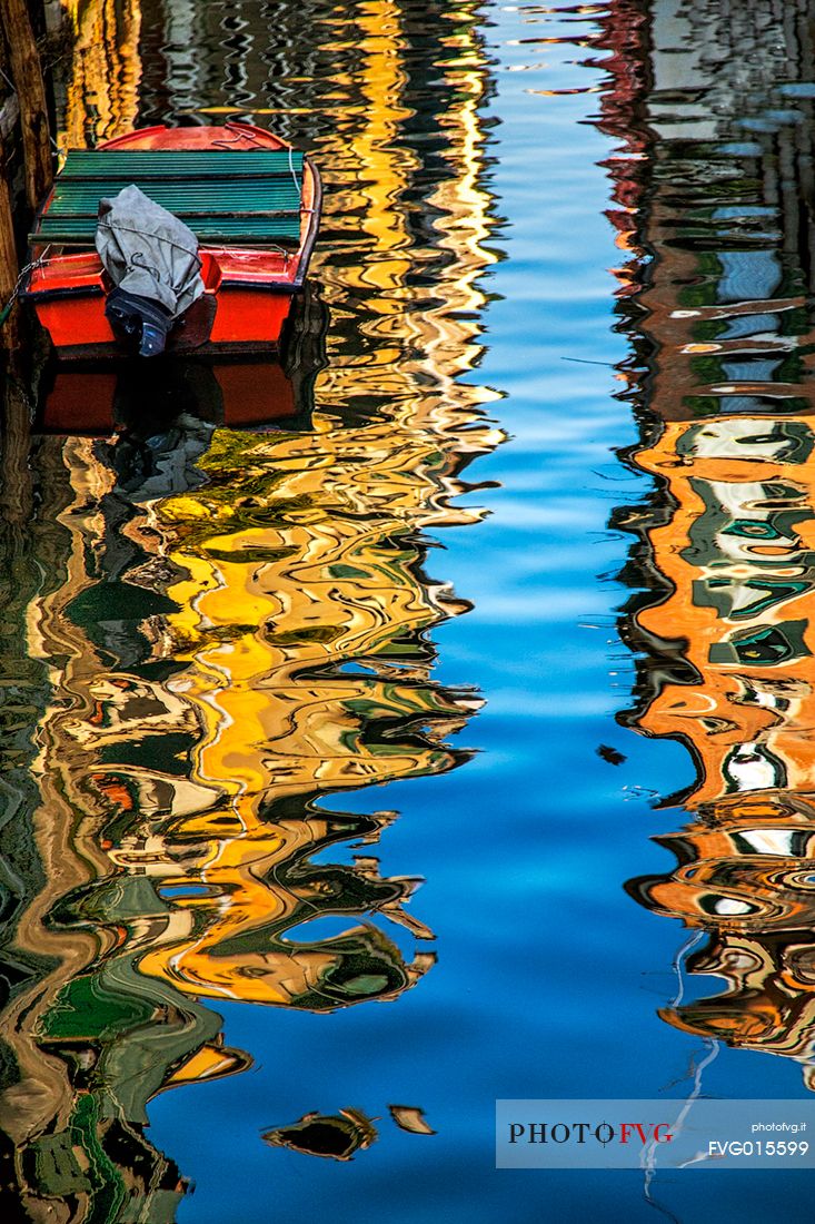 The colors of the reflections of gondolas and Venetian houses on the canal in a sunny day