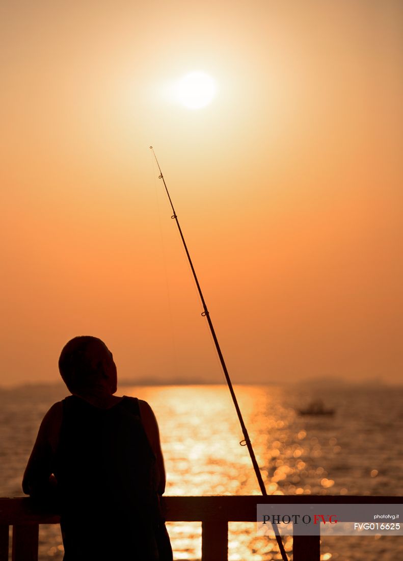 The wait of a fisherman during a summer sunrise
