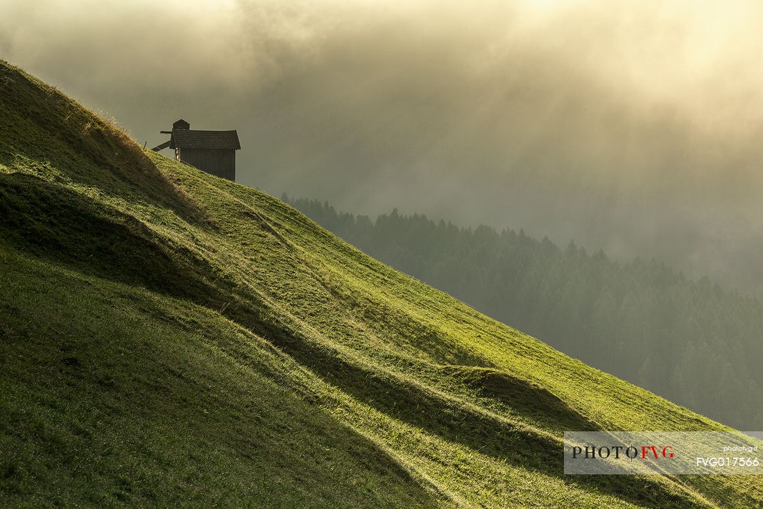Dawn light rays on meadows of Sesto in Pustertal
