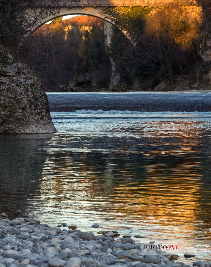 Golden reflections on the Natisone river under the Devil's bridge in Cividale Del Friuli