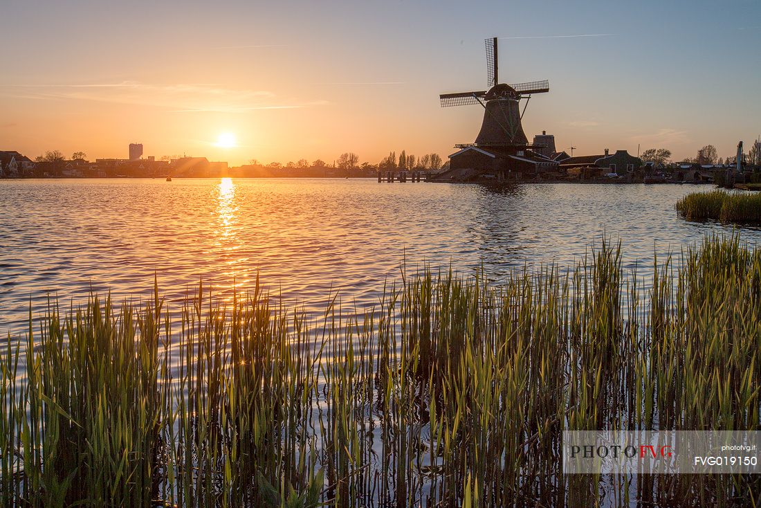 Windmills at sunset along the banks of the river Zaan in the little village of Zaanse Schans