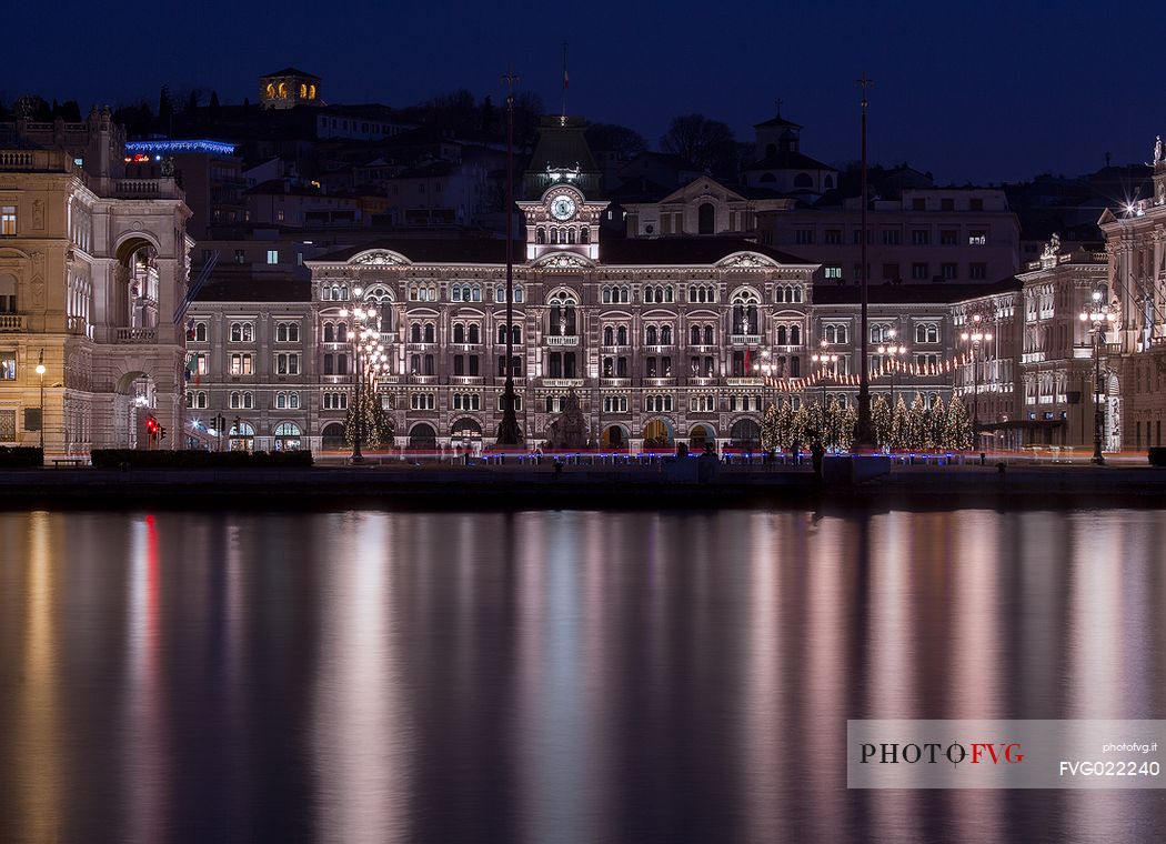 The Town Hall reflected on the waterfront of Trieste in the Piazza Unit d'Italia square at Christmas time, Italy
