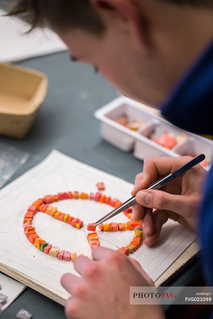 Young boy learns the art of mosaic in the oldest Mosaic School of Friuli, Italy