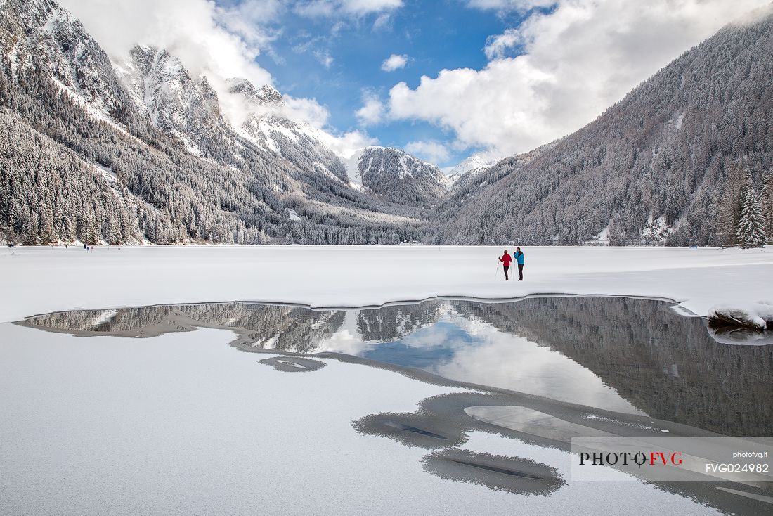 Cross country skiers admire the majestic winter landscape of Anterselva lake, Pusteria Valley, Italy