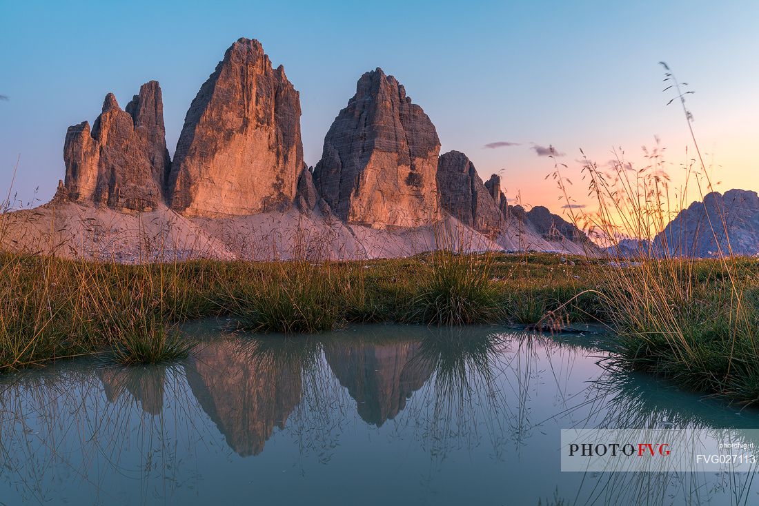Tre Cime di Lavaredo reflected on a little pond in the Tre Cime Natural Park, Dolomites, South Tyrol, Italy
