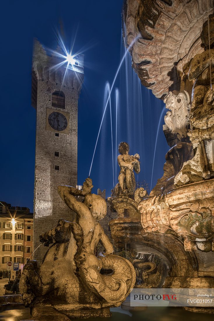 The fountain of Nettuno and the Civic tower in Duomo square at the twilight, Trento, Trentino Alto Adige, Italy