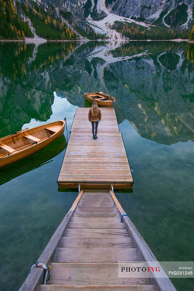 Tourist on the pier of the Braies Lake Dolomites, Pusteria Valley, Italy