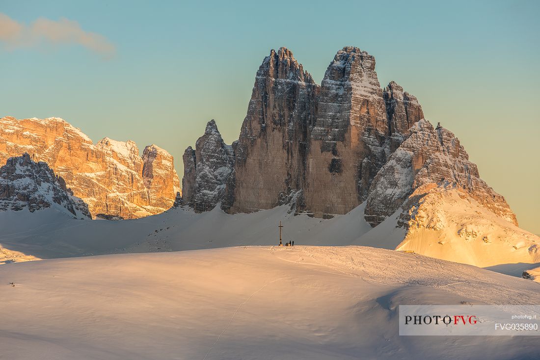 The summit cross of the Specie Mount and the Tre Cime di Lavaredo on background at sunset, Prato Piazza, Braies, Trentino Alto Adige, Italy