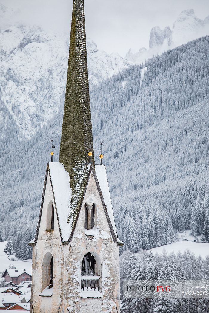 The snow covered bell tower of the church of Villabassa, Trentino Alto Adige, dolomites, Pusteria valley, Italy, Europe
