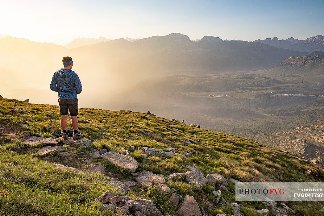 Trekker admires the panoramic view over the Rolle Pass, San Martino di Castrozza, dolomites, Trentino Alto Adige, Italy, Europe