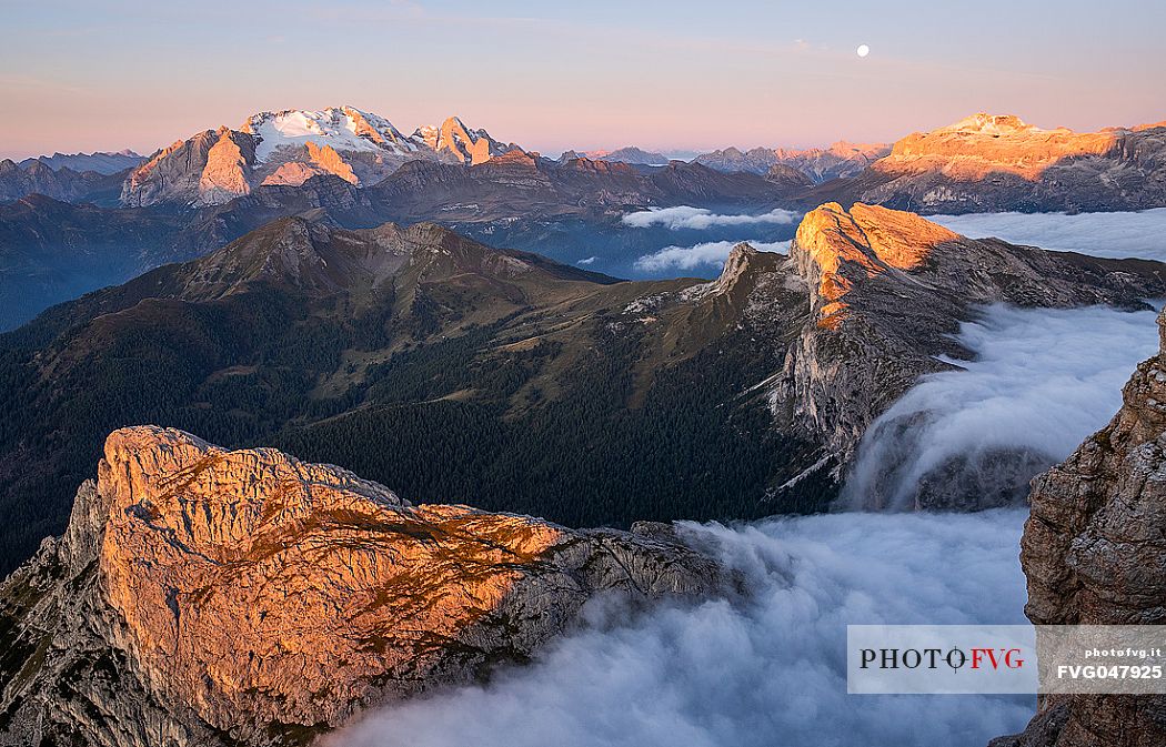 Clouds wrap around the landscape nearby Lagazuoi refuge at dawn, in the background the Marmolada mount, Cortina d'Ampezzo, Veneto, Italy, Europe