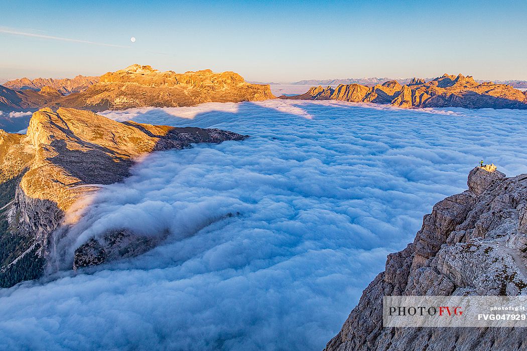 Hiker looks the sunrise and the clouds wrap around the landscape nearby Lagazuoi Refuge, Cortina d'Ampezzo, Veneto, Italy, Europe