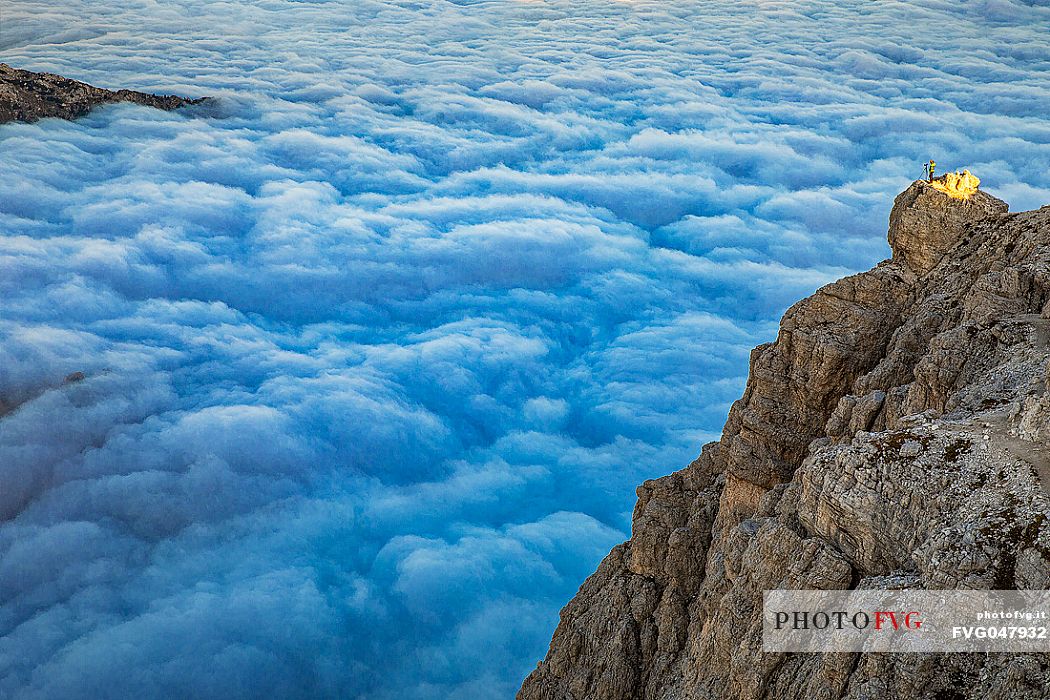 Photographer sourranded by a low clouds sea on the top of Lagazuoi mount, Cortina d'Ampezzo, dolomites, Veneto, Italy, Europe