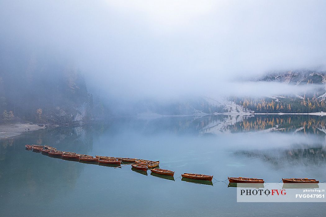 Row of boats moored in the lake of Braies in autumn, dolomites, Pusteria valley, Trentino Alto Adige, South Tyrol, Italy, Europe