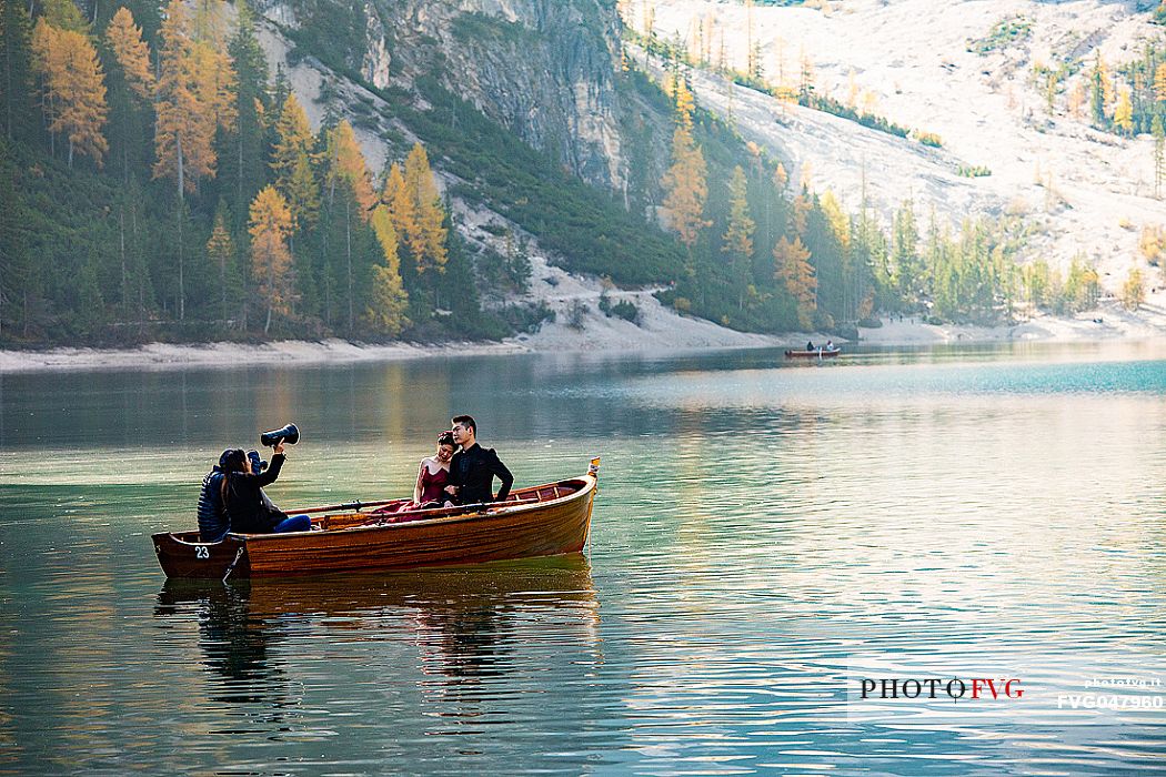 Photo shooting for a pair on Lake Braies with autumn colors, dolomites, Pusteria valley, Trentino Alto Adige, South Tyrol, Italy, Europe