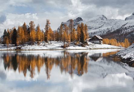 Autumn with snow on the Federa lake with the Palmieri refuge and the Becco di Mezzodi' on background 