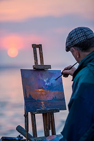 The Painter colors his picture on the Canal Grande in Venice during a sunset