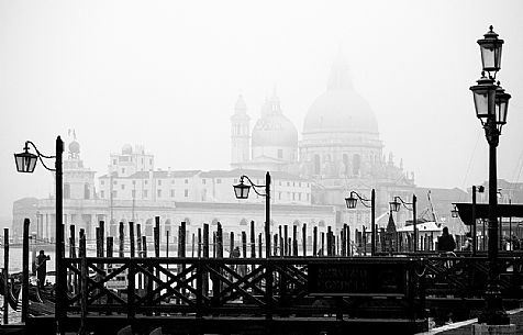 Venetian gondolas with the Basilica of St Mary of Health (commonly known simply as the Salute )cover by fog 