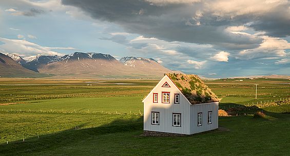 An ancient factory  with roof in moss and typical icelandic landscape