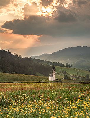 The church of San Giovanni in Funes valley during a special spring sunset
