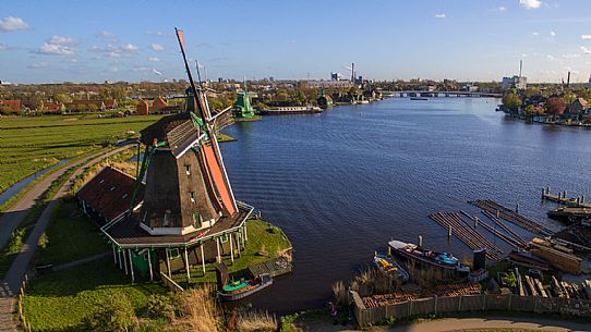 Zaanse Schans , the small community of 40 homes located north - east of Amsterdam , on the quay of the river Zaan , famous for its windmills