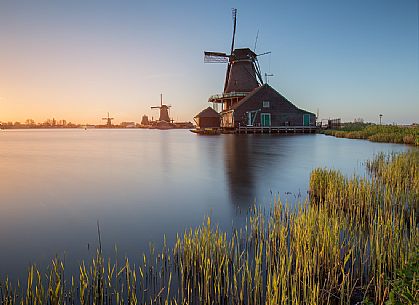 Windmills at sunset along the banks of the river Zaan in the little village of Zaanse Schans