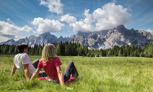 Two tourists on the lawns of the Alpe Nemes hut with the Sesto peaks in the background