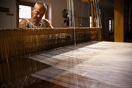 Hand weaver Herman Kühebacher of Villabassa, the only one of South Tyrol using today still the traditional technique of weaving to handle and to use almost exclusively of natural fibers of wool and linen not treated with chemical products